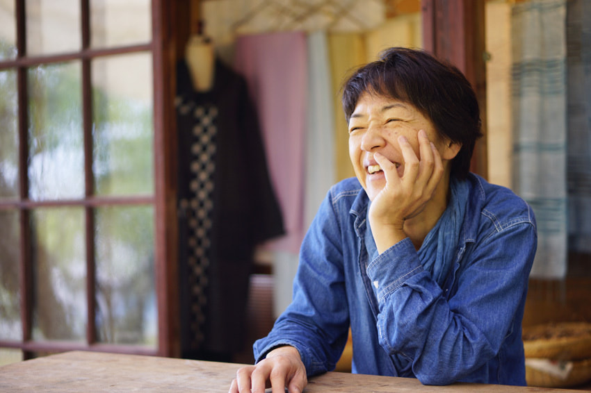 テーブルに座りながら微笑む女性